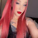 Miss Red, Denver escort with long red hair, blue eyes, red lipstick, and tattoos